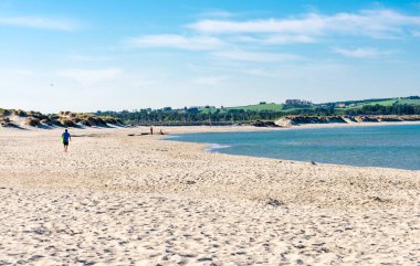 A few people on a long Sola beach waiting for an upcoming summer season, Stavanger, Norway, May 2018