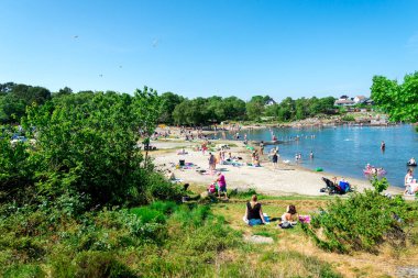 A view to crowded Vaulen beach popular by local public for swimming in summer, Stavanger, Norway, June 2018