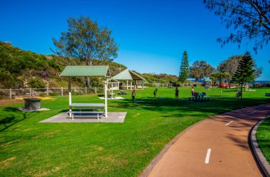 Yürüyüş Yolu ve Kapalı Piknik Alanlı Yeşil Park Iluka 'da güneşli bir günde, Perth, Avustralya, Mart 2020
