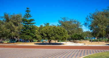 Bengello Park Girişi 'ne manzara manzarası Açık Mavi Gök Altında Yeşil Ağaçlar Burns Sahili, Joondalup, Batı Avustralya, 11 Nisan 2020