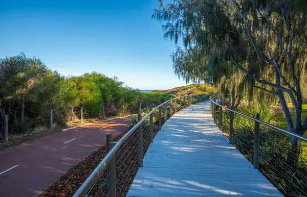 Burns Beach, Joondalup City, Batı Avustralya 'da Açık Mavi Gök Altında Lush Yeşilliği ile çevrili Manzaralı Yürüyüş ve Yol, 11 Nisan 2020