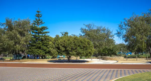 Bengello Park Girişi 'ne manzara manzarası Açık Mavi Gök Altında Yeşil Ağaçlar Burns Sahili, Joondalup, Batı Avustralya, 11 Nisan 2020