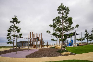 Mullaloo Beach, Perth, Avustralya, 12 Nisan 2020 'de Lush Trees ve Open Sky tarafından çevrelenmiş Modern ekipmanlı açık hava oyun parkı