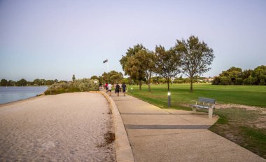 Sunset, Güney Perth, Avustralya 'da Kuğu Nehri Sahili Sahili' nin yanında Yürüyen İnsanlar, 15 Nisan 2020