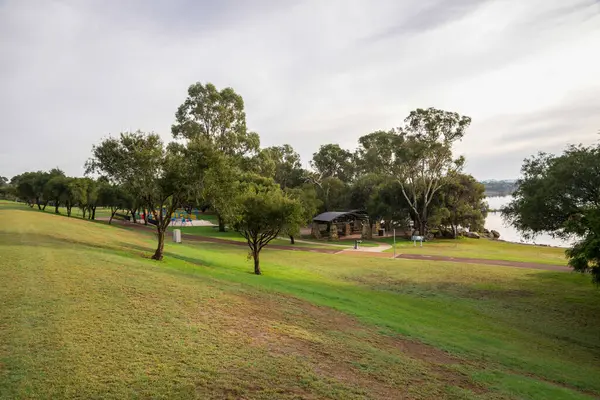 Gökyüzü, Perth, Avustralya, 27 Nisan 2020 'de Gökyüzü altında Yeşil Çimen ve Ağaçlarla Sahne Pikniği Koyu Parkı