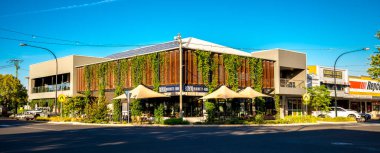 Modern Yerel Pub Binası 29 Kasım 2020 'de Vibrant Town Street Corner, Roma, Avustralya' da Yeşillik ile kaplandı.