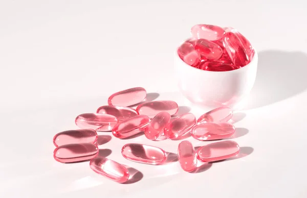 Pink transparent capsules, Food supplement oil filled fish oil, omega 3, omega 6, omega 9, vitamin A, vitamin D, vitamin E, flaxseed oil.