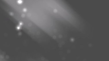Bulanık ışık ışınları ve gri bir arka planda bokeh. Soyut arka planlar, sanatsal tasarımlar, web sitesi başlıkları ve sosyal medya paylaşımları için elverişli.