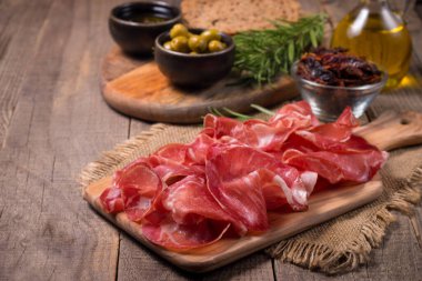Italian slices of coppa, capocollo, capicollo, bresaola or cured ham with rosemary. Raw food
