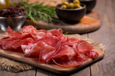 Italian slices of coppa, capocollo, capicollo, bresaola or cured ham with rosemary. Raw food