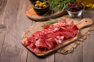 Italian slices of coppa, capocollo, capicollo, bresaola or cured ham with rosemary. Raw food