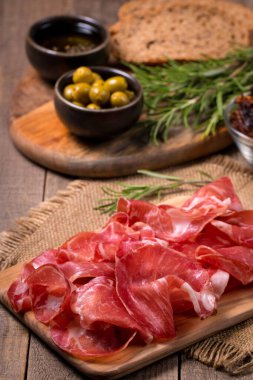 Italian slices of coppa, capocollo, capicollo, bresaola or cured ham with rosemary. Raw food