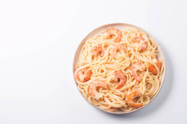 Italian pasta fettuccine or spaghetti in a creamy cheese sauce with shrimp or prawns on a plate