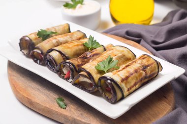 Baked grilled eggplant rolls with cottage cheese, tomatoes and sour cream. Georgian cuisine. 