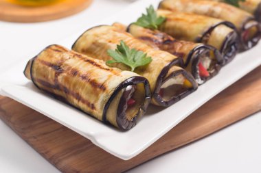 Baked grilled eggplant rolls with cottage cheese, tomatoes and sour cream. Georgian cuisine. 