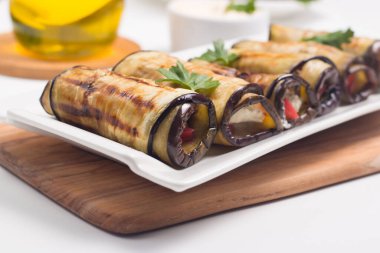 Baked grilled eggplant rolls with cottage cheese, tomatoes and sour cream. Georgian cuisine. 