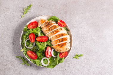 Salad with grilled chicken fillet meat, fresh vegetables, spinach, ruccola, red onion and tomato. Healthy menu. Diet food. Top view. Banner 
