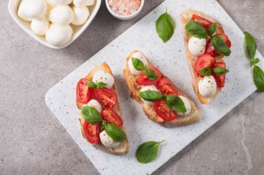 Domates, fesleğen ve mozzarella peyniri taze Caprese Bruschetta. İtalyan mezesi, sebzeli pandispanya ızgara ciabatta ve baget ekmekli yağ. Sandviç aç.