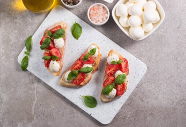 Domates, fesleğen ve mozzarella peyniri taze Caprese Bruschetta. İtalyan mezesi, sebzeli pandispanya ızgara ciabatta ve baget ekmekli yağ. Sandviç aç.