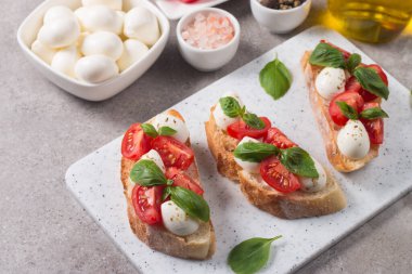 Domates, fesleğen ve mozzarella peyniri taze Caprese Bruschetta. İtalyan mezesi, sebzeli pandispanya ızgara ciabatta ve baget ekmekli yağ. Sandviç aç.