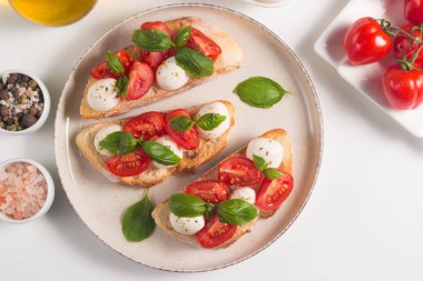 Domates, fesleğen ve mozzarella peyniri taze Caprese Bruschetta. İtalyan mezesi, sebzeli pandispanya ızgara ciabatta ve baget ekmekli yağ. Sandviç aç.