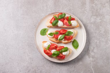 Domates, fesleğen ve mozzarella peyniri taze Caprese Bruschetta. İtalyan mezesi, sebzeli pandispanya ızgara ciabatta ve baget ekmekli yağ. Sandviç aç.