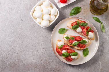 Domates, fesleğen ve mozzarella peyniri taze Caprese Bruschetta. İtalyan mezesi, sebzeli pandispanya ızgara ciabatta ve baget ekmekli yağ. Sandviç aç.