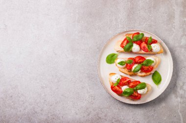 Domates, fesleğen ve mozzarella peyniri taze Caprese Bruschetta. İtalyan mezesi, sebzeli pandispanya ızgara ciabatta ve baget ekmekli yağ. Sandviç aç.