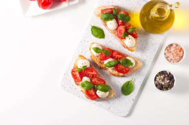 Domates, fesleğen ve mozzarella peyniri taze Caprese Bruschetta. İtalyan mezesi, sebzeli pandispanya ızgara ciabatta ve baget ekmekli yağ. Sandviç aç.
