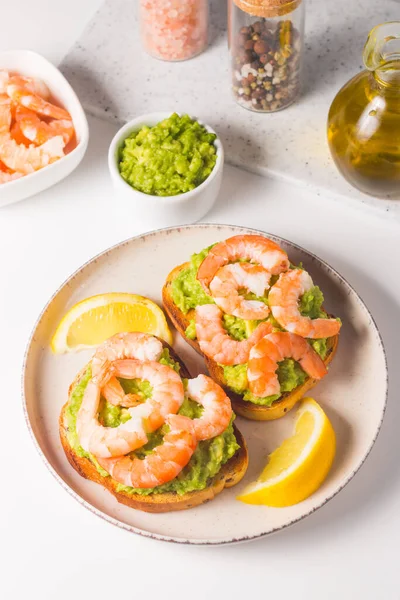 stock image Shrimps on toast with avocado and lemon. Breakfast concept. Bruschetta. 