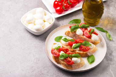 Domates, fesleğen ve mozzarella peyniri taze Caprese Bruschetta. İtalyan mezesi, sebzeli pandispanya ızgara ciabatta ve baget ekmekli yağ. Sandviç aç.