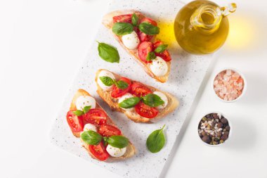 Domates, fesleğen ve mozzarella peyniri taze Caprese Bruschetta. İtalyan mezesi, sebzeli pandispanya ızgara ciabatta ve baget ekmekli yağ. Sandviç aç.