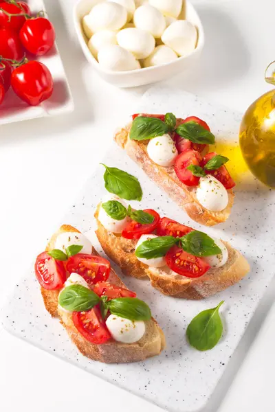 Domates, fesleğen ve mozzarella peyniri taze Caprese Bruschetta. İtalyan mezesi, sebzeli pandispanya ızgara ciabatta ve baget ekmekli yağ. Sandviç aç.