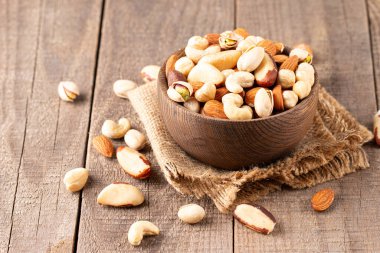 Ahşap arka plan üzerinde sağlıklı karışımı fındık. Badem, fındık, kaju fıstığı, fıstık, Antep fıstığı, Brezilya fındık