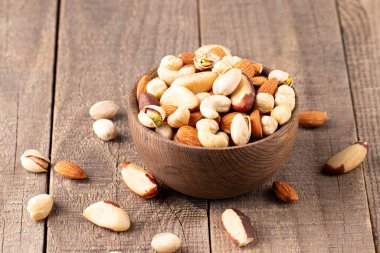 Ahşap arka plan üzerinde sağlıklı karışımı fındık. Badem, fındık, kaju fıstığı, fıstık, Antep fıstığı, Brezilya fındık