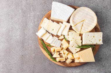 Çeşitli peynirler ve zeytinlerle ahşap tahta. Krem peynir. Camembert peyniri. Parmesan, feta, mavi peynir. İtalyan, Fransız peyniri.