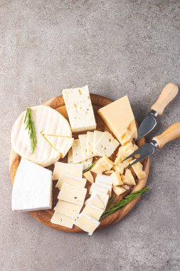 Çeşitli peynirler ve zeytinlerle ahşap tahta. Krem peynir. Camembert peyniri. Parmesan, feta, mavi peynir. İtalyan, Fransız peyniri.