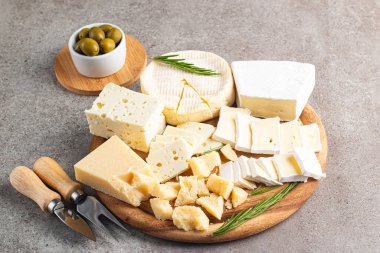 Çeşitli peynirler ve zeytinlerle ahşap tahta. Krem peynir. Camembert peyniri. Parmesan, feta, mavi peynir. İtalyan, Fransız peyniri.