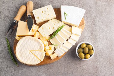 Çeşitli peynirler ve zeytinlerle ahşap tahta. Krem peynir. Camembert peyniri. Parmesan, feta, mavi peynir. İtalyan, Fransız peyniri.