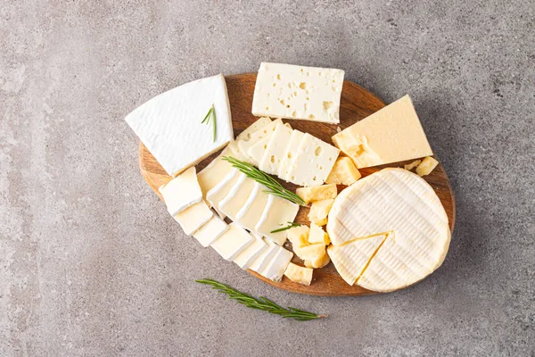 Çeşitli peynirler ve zeytinlerle ahşap tahta. Krem peynir. Camembert peyniri. Parmesan, feta, mavi peynir. İtalyan, Fransız peyniri.