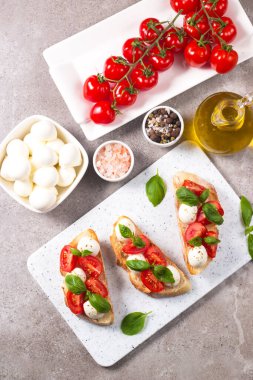 Domates, fesleğen ve mozzarella peyniri taze Caprese Bruschetta. İtalyan mezesi, sebzeli pandispanya ızgara ciabatta ve baget ekmekli yağ. Sandviç aç.