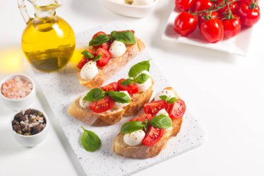 Domates, fesleğen ve mozzarella peyniri taze Caprese Bruschetta. İtalyan mezesi, sebzeli pandispanya ızgara ciabatta ve baget ekmekli yağ. Sandviç aç.