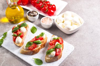 Domates, fesleğen ve mozzarella peyniri taze Caprese Bruschetta. İtalyan mezesi, sebzeli pandispanya ızgara ciabatta ve baget ekmekli yağ. Sandviç aç.