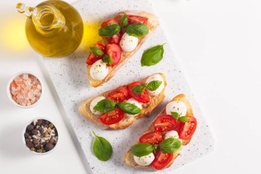 Domates, fesleğen ve mozzarella peyniri taze Caprese Bruschetta. İtalyan mezesi, sebzeli pandispanya ızgara ciabatta ve baget ekmekli yağ. Sandviç aç.