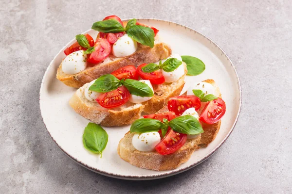 Domates, fesleğen ve mozzarella peyniri taze Caprese Bruschetta. İtalyan mezesi, sebzeli pandispanya ızgara ciabatta ve baget ekmekli yağ. Sandviç aç.