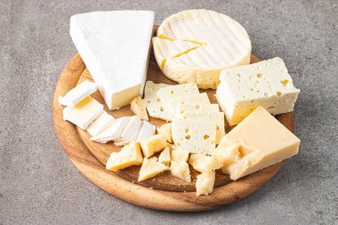 Çeşitli peynirler ve zeytinlerle ahşap tahta. Krem peynir. Camembert peyniri. Parmesan, feta, mavi peynir. İtalyan, Fransız peyniri.