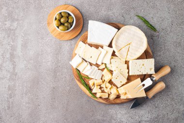 Çeşitli peynirler ve zeytinlerle ahşap tahta. Krem peynir. Camembert peyniri. Parmesan, feta, mavi peynir. İtalyan, Fransız peyniri.