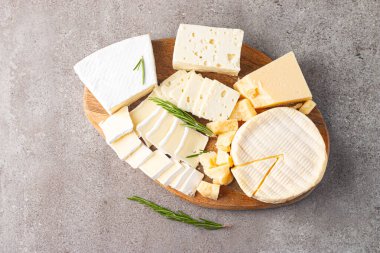 Çeşitli peynirler ve zeytinlerle ahşap tahta. Krem peynir. Camembert peyniri. Parmesan, feta, mavi peynir. İtalyan, Fransız peyniri.