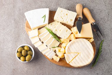 Çeşitli peynirler ve zeytinlerle ahşap tahta. Krem peynir. Camembert peyniri. Parmesan, feta, mavi peynir. İtalyan, Fransız peyniri.