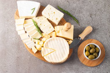 Çeşitli peynirler ve zeytinlerle ahşap tahta. Krem peynir. Camembert peyniri. Parmesan, feta, mavi peynir. İtalyan, Fransız peyniri.